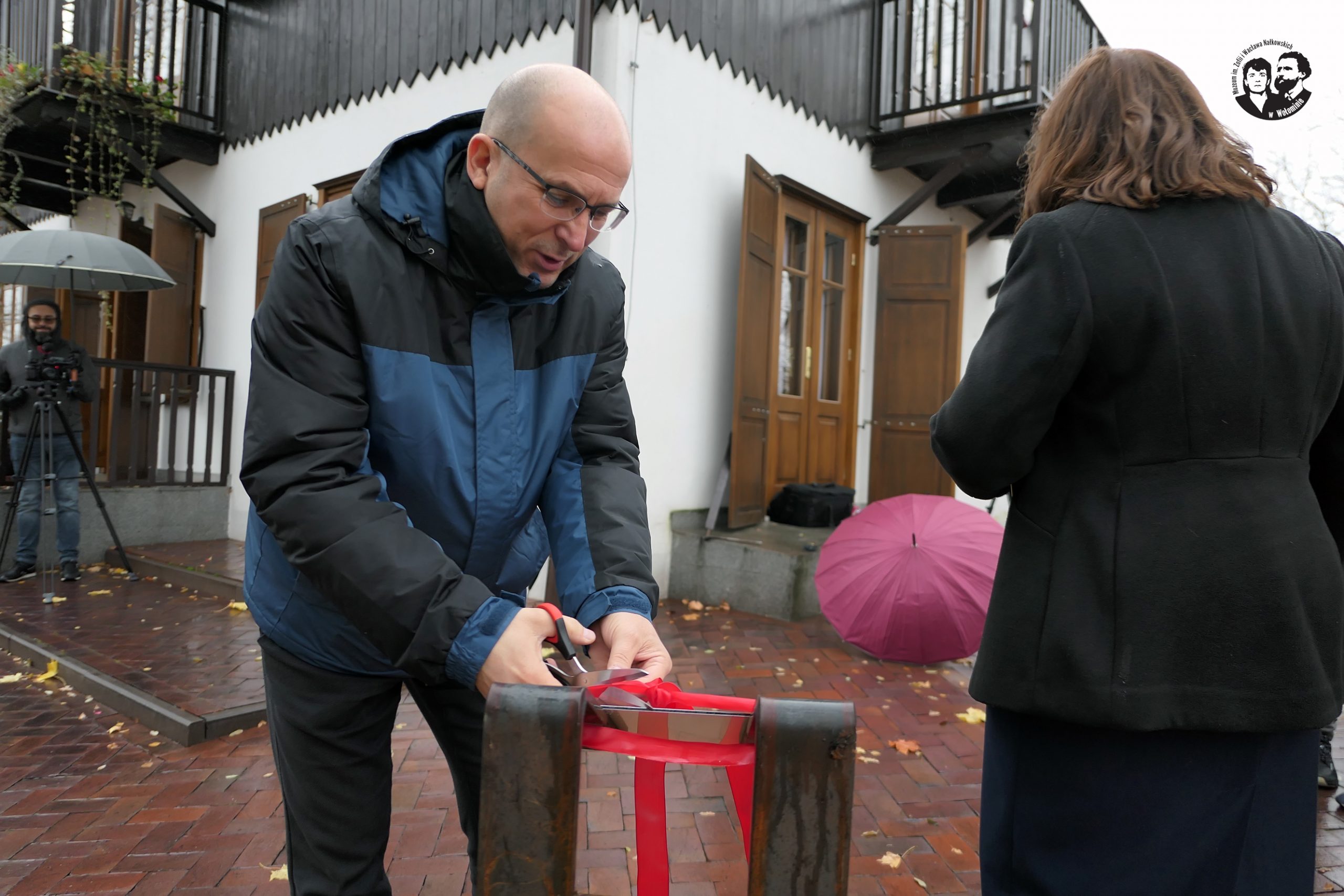 Fotografia kolorowa pozioma, przedstawiająca moment przecinania wstęgi przez Burmistrza Dariusza Szymanowskiego