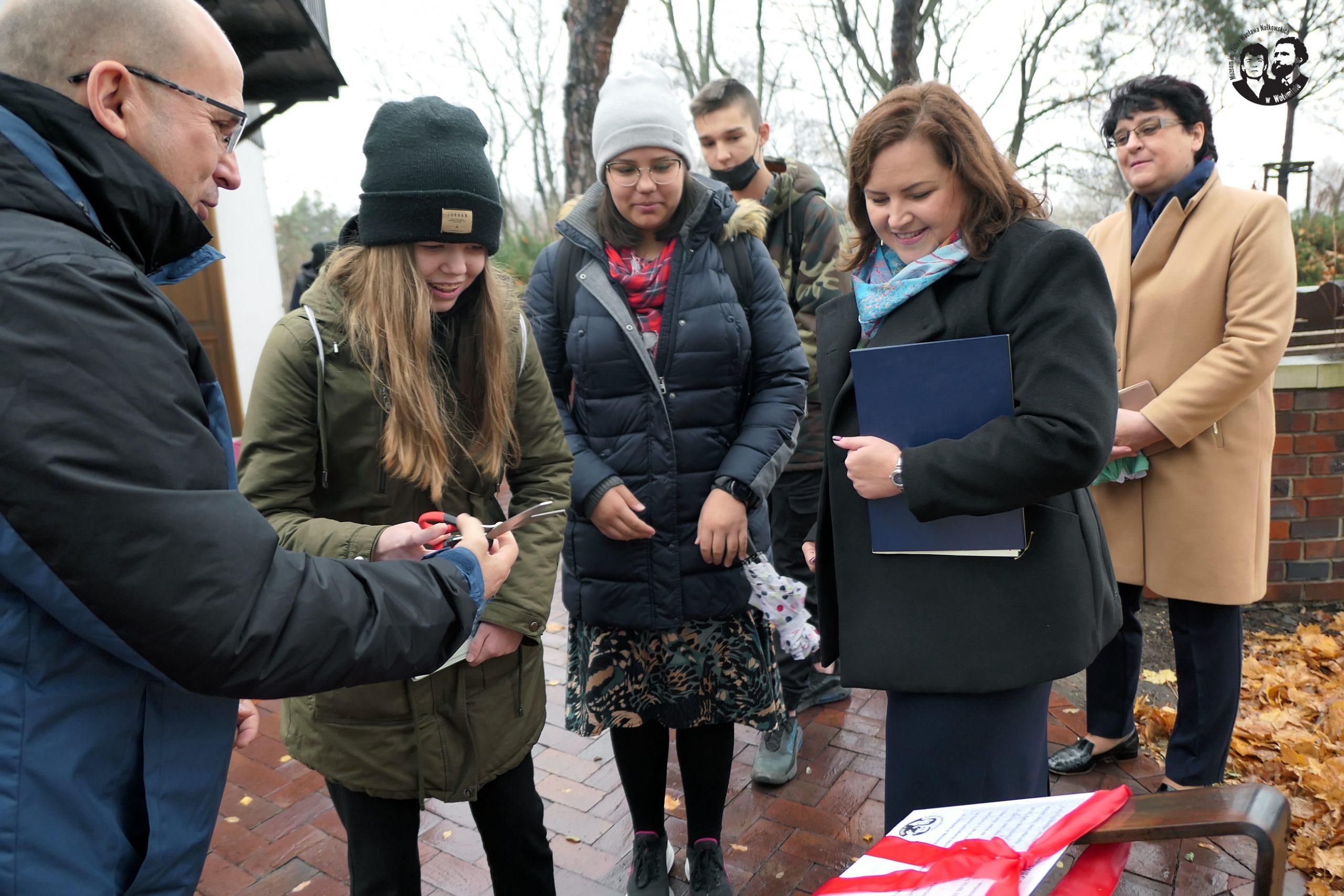 Fotografia kolorowa pozioma, przedstawiająca moment przekazania przez Burmistrza Szymanowskiego nożyczek przedstawicielce młodzieży